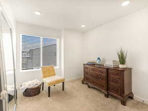 Sitting room with light carpet, baseboards, and recessed lighting