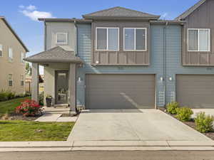 Townhome / multi-family property featuring a garage, concrete driveway, and a shingled roof