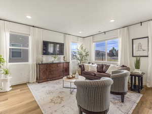 Living area with light wood-style flooring, recessed lighting, and baseboards