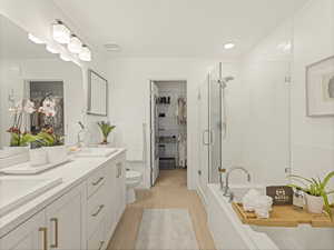 Full bathroom with a stall shower, a walk in closet, double vanity, toilet, and a bath