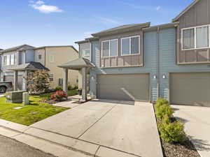 Townhome / multi-family property featuring board and batten siding, a garage, and concrete driveway
