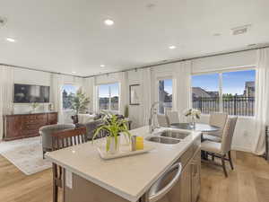 Kitchen featuring a sink, dishwasher, light wood finished floors, recessed lighting, and open floor plan