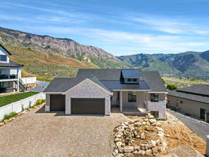 Modern farmhouse featuring a standing seam roof, an attached garage, driveway, and a mountain view