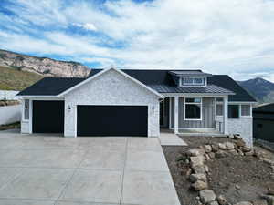 View of front of property with a mountain view, covered porch, a standing seam roof, a metal roof, and stone siding