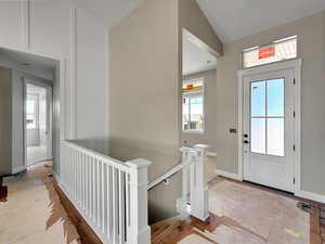 Entryway featuring lofted ceiling and baseboards