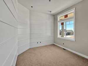 Carpeted empty room featuring baseboards
