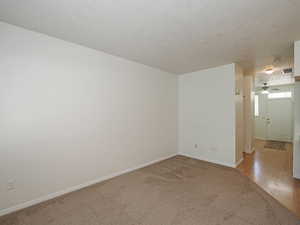 Spare room with light colored carpet, baseboards, and ceiling fan