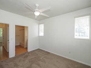Unfurnished bedroom featuring carpet, multiple windows, baseboards, and a ceiling fan