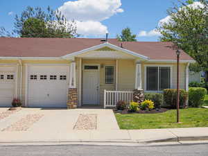 View of front facade with driveway, a garage, and covered porch