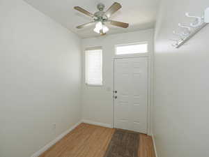 Foyer with light wood-style flooring, baseboards, and ceiling fan