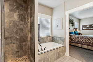 Bathroom with connected bathroom, a bath, tiled shower, and healthy amount of natural light