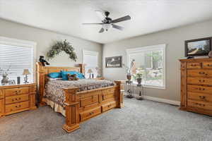 Bedroom with light carpet, baseboards, and a ceiling fan