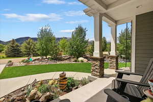 Porch featuring a mountain view and a yard