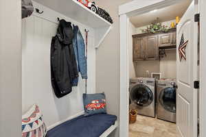 Laundry room with washer and clothes dryer and cabinet space