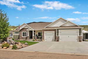Craftsman house featuring an attached garage, covered porch, a shingled roof, and driveway