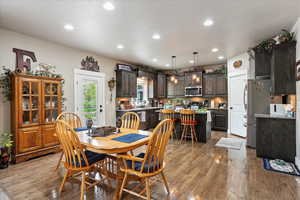 Dining room with light wood-type flooring and recessed lighting