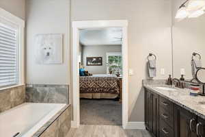 Full bathroom with ensuite bathroom, a garden tub, ceiling fan, and double vanity