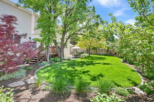 View of yard with a patio, a deck, and stairway