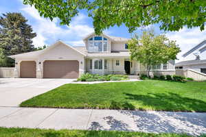 View of front of home featuring an attached garage, stucco siding, concrete driveway, and stone siding