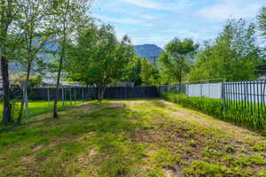 View of fully fenced back portion of yard with alley access