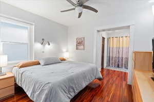 Bedroom with dark wood-type flooring and a ceiling fan