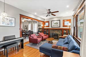 Living room featuring a ceiling fan, light wood-style floors, a fireplace, healthy amount of natural light, and recessed lighting