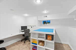 Carpeted office space featuring baseboards