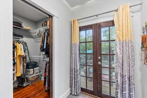 Interior space with french doors, baseboards, and wood finished floors