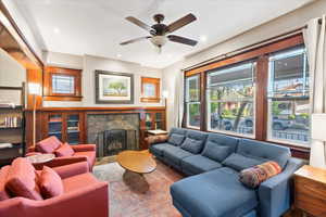 Living room with a fireplace, ceiling fan, and recessed lighting