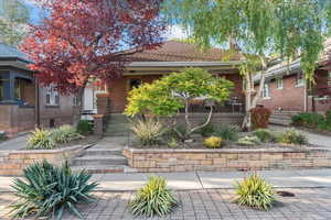 View of property hidden behind natural elements with brick siding