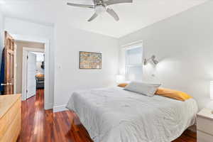Bedroom featuring dark wood finished floors, ceiling fan, and baseboards