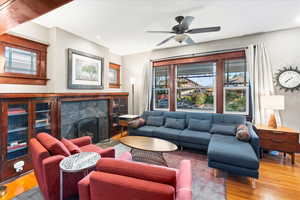 Living room featuring wood finished floors, recessed lighting, a fireplace, and ceiling fan