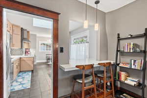 Dining space featuring dark tile patterned flooring and baseboards