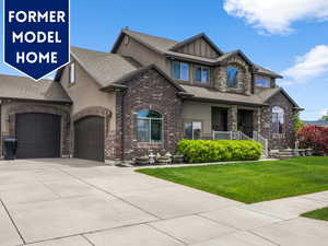 View of front of home with stucco siding, an attached garage, a front yard, concrete driveway, and covered porch