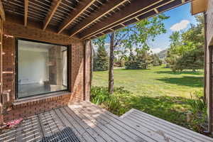 Wooden deck featuring a lawn and a mountain view