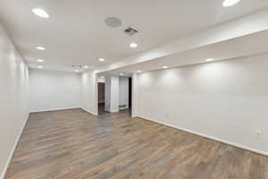 Finished below grade area with baseboards, wood finished floors, and recessed lighting