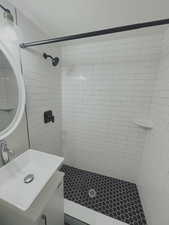 Full bathroom with tiled shower and vanity