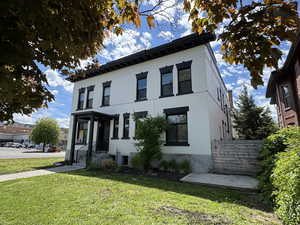 View of front of property featuring a front lawn and brick siding
