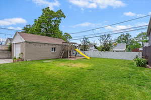 View of yard with a playground and a garage