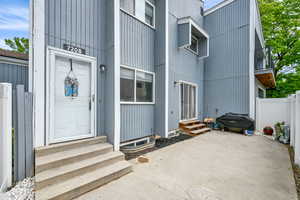 Entrance to property with fence and a patio area