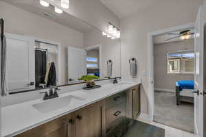 Full bath featuring double vanity, baseboards, ensuite bath, tile patterned flooring, and a ceiling fan