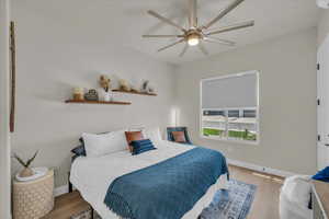 Bedroom with wood finished floors, baseboards, and ceiling fan