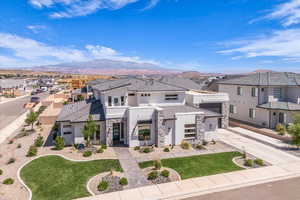 Contemporary home featuring stone siding, stucco siding, a residential view, and a tile roof
