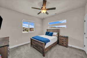 Bedroom with baseboards, light carpet, and ceiling fan