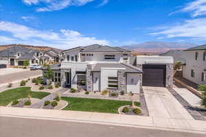 Contemporary home with stone siding, stucco siding, concrete driveway, and a mountain view