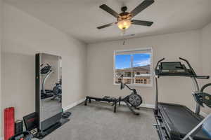 Workout room with carpet floors, a ceiling fan, and baseboards