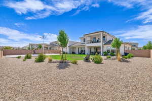 Rear view of property featuring a balcony, stucco siding, and a patio area