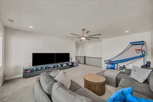 Living area with carpet floors, ceiling fan, recessed lighting, and baseboards