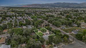 Aerial perspective of suburban area featuring a mountainous background and property parcel outlined
