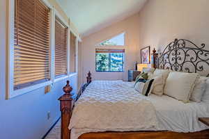 Bedroom with vaulted ceiling, carpet, and baseboards